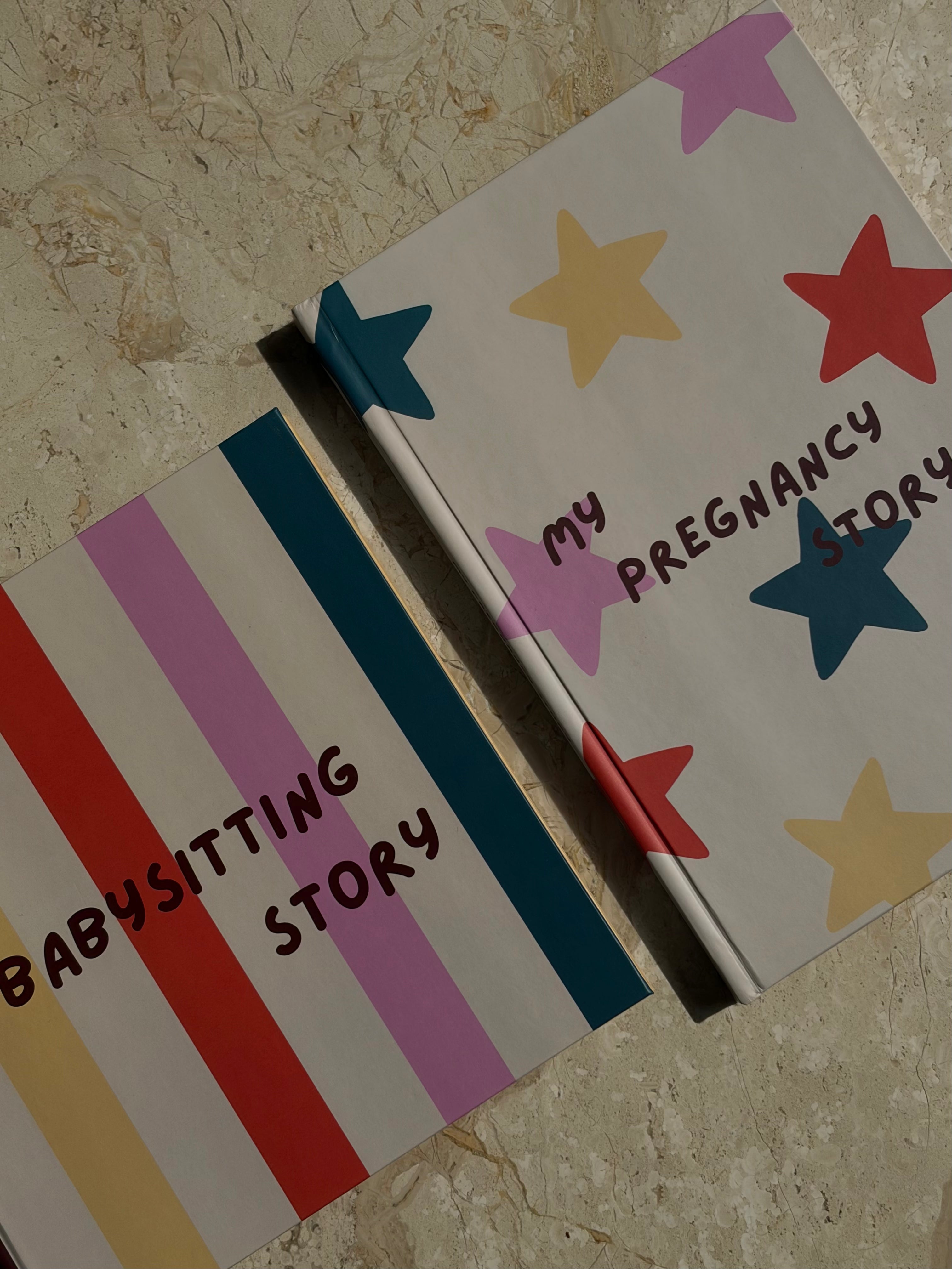 Kleurrijke bundel met een zwangerschaps-invulboek met sterrenprint voor toekomstige mama's en papa's en een oppas-invulboek met streepprint voor kinderen van 0 tot 4 jaar. De combinatie van bordeaux, roze, geel, oranje en petrol zorgt voor een vrolijke en speelse uitstraling.